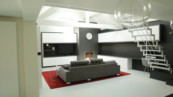 Les meubles de rangement du salon sont en MDF laqué blanc rehaussé par un cadre en stratifié bois noir. Un bureau avec un plan de travail a été aménagé dans la continuité des éléments.