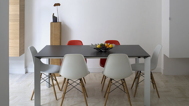 Côté salle à manger, on a conservé le mobilier existant. Les chaises rouges et blanches (Plastic Chair, création Ray & Charles Eames pour Vitra) et la table à rallonges, avec plateau en résine gris anthracite et piétement métal (modèle Nori de chez Kristalia) s’intègrent naturellement dans l’espace modernisé. À l’arrière plan, le bloc vertical rappelle le chêne, matériau dominant au rez-de-chaussée. Côté salle à manger, on a conservé le mobilier existant. Les chaises rouges et blanches (Plastic Chair, création Ray & Charles Eames pour Vitra) et la table à rallonges, avec plateau en résine gris anthracite et piétement métal (modèle Nori de chez Kristalia) s’intègrent naturellement dans l’espace modernisé. À l’arrière plan, le bloc vertical rappelle le chêne, matériau dominant au rez-de-chaussée.