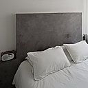 Le lit est intégré dans une tête de lit en béton ciré qui offre l’espace d’une petite tablette de chaque côté.