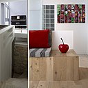 Derrière la banquette et caché derrière un muret, l’escalier permet d’accéder au niveau inférieur du duplex. Cet espace est ouvert sur un jardin en contrebas et accueille deux chambres accompagnées de leur salle de bains particulière et d’un espace de stockage. Quant à l’ancien escalier imposant et encombrant, autrefois aménagé à la place de l’actuelle banquette et qui permettait de monter au salon de musique, il a été supprimé et remplacé par un accès et une circulation sur la droite, avec trois marches.