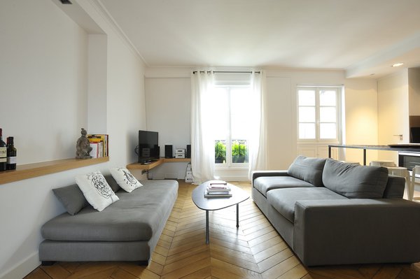 Des étagères murales assurent le rangement du matériel TV, Hifi et des livres.