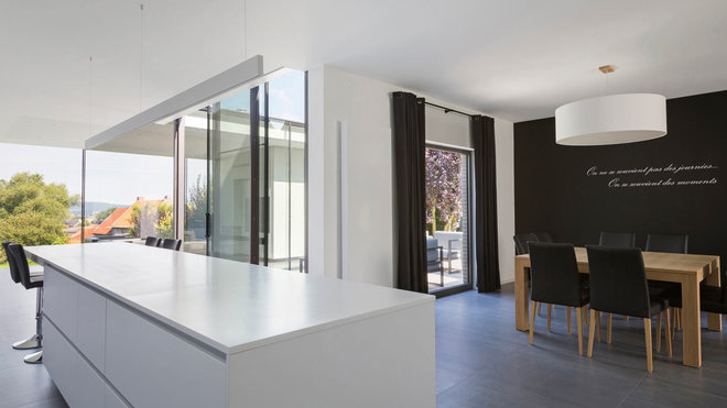 L’îlot de la cuisine est terminé par un bar et une vraie table de repas occupe l’espace de l’ancienne salle à manger. Le sol est composé de grandes dalles de grès cérame.