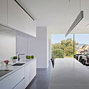 L’espace joue la carte du noir et blanc. Les rangements de la cuisine ont été aménagés à partir de caissons modulaires de cuisiniste recomposés et redimensionnés par les architectes de l’agence Crahay et Jamaigne. Plan de travail en pierre reconstituée.