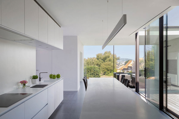 L’espace joue la carte du noir et blanc. Les rangements de la cuisine ont été aménagés à partir de caissons modulaires de cuisiniste recomposés et redimensionnés par les architectes de l’agence Crahay et Jamaigne. Plan de travail en pierre reconstituée.