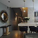 La cuisine s’inscrit naturellement dans l’espace. Sa partie technique est partiellement occultée par un panneau mural en marbre. Suspensions lumineuses, CTO Lighting. Console, Christian Liaigre et miroir, Hervé Van der Straeten.