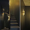 L’escalier a été traité volontairement dans des tons foncés avec des marches en béton ciré. Des suspensions lumineuses, modèle Rudi (Roll and Hill) et des appliques en marbre et laiton, modèle Niagara en forme de trombone (Ginger and Jagger) éclairent la cage d’escalier comme des bijoux.