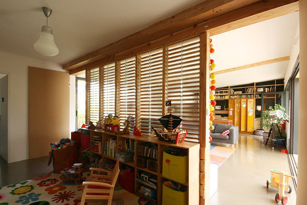 La salle de jeux est aussi un espace de circulation vers les chambres des enfants et la salle de bains. En partie haute, le vitrage armé de récupération permet d’apporter de la lumière dans cette pièce enclavée.