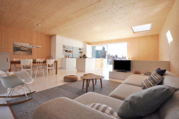 Au second niveau, une grande pièce à vivre lovée dans un cocon de bois.