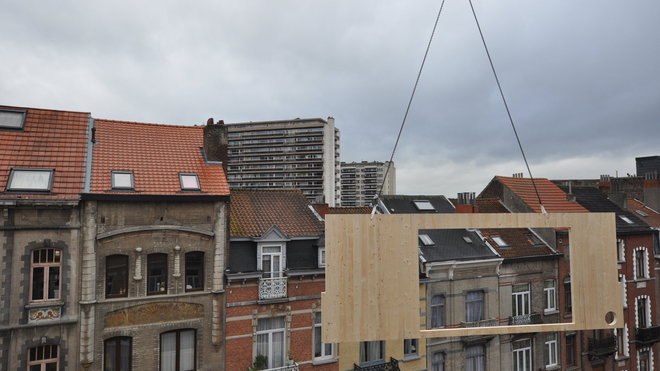 Photo de chantier : côté rue, deuxième jour de montage du panneau de façade marqué par l’ouverture de la grande baie vitrée.