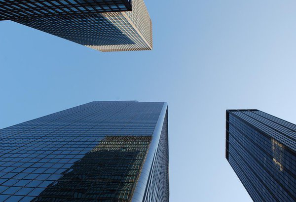 Vue vertigineuse de l'Empire State Building et de deux gratte-ciel qui l'entourent.