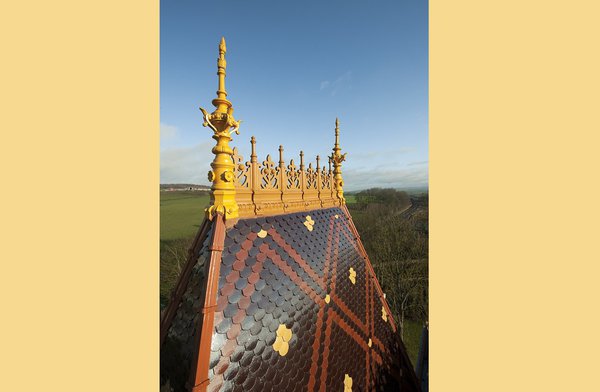 Restitution des épis faîtage de la toiture en tuiles vernissées et colorées, parachevant la restauration.