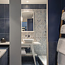 Dans la salle de bains, une fresque en carrelage aux couleurs aquatiques et aux motifs floraux adoucie les lignes très contemporaines de l’espace.