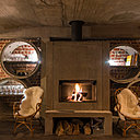 La cheminée en béton du bar est encadrée par des étagères circulaires également en béton.