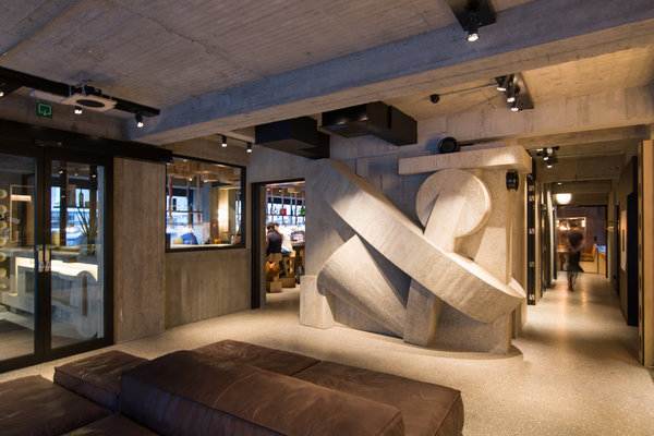 Dans le hall, béton massif ou factice et sculpture assemblée d’éléments de plafond de Jules Wabbes et Christophe Gevers avec pièces en marbre. « Le reste des murs (du lobby) est traité comme une grande sculpture constructiviste. » Lionel Jadot.