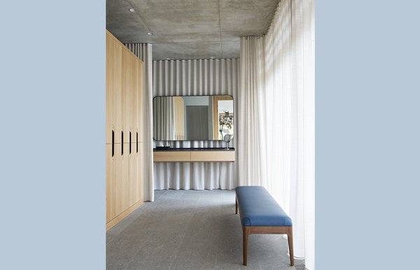 On a mis un point d’honneur à rendre invisible toute la technique : aucune fixation apparente dans la partie vestiaire, les coiffeuses sont suspendues et les portes en verre fumé ne révèlent pas leurs gonds.