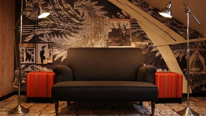 Sous les toits, un effet de dentelle XXL et des pages de carnets de tendances animent le mur qui met en valeur un canapé monochrome posé sur un sol animé d’un effet de trompe-l’œil de pavement ancien. Les lampadaires de type industriel et les poufs carrés apportent une touche plus actuelle. Sous les toits, un effet de dentelle XXL et des pages de carnets de tendances animent le mur qui met en valeur un canapé monochrome posé sur un sol animé d’un effet de trompe-l’œil de pavement ancien. Les lampadaires de type industriel et les poufs carrés apportent une touche plus actuelle.