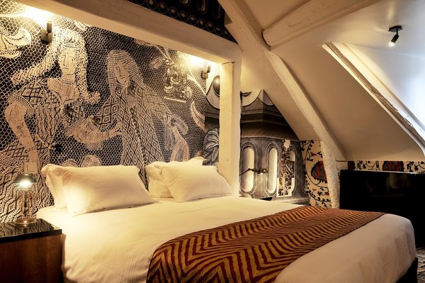 L’architecture de cet espace est mise en valeur par un mixage de papiers-peints aux motifs très contrastés. Sous la poutraison, en tête de lit, papier-peint avec effet XXL de dentelle aux fuseaux en continu.