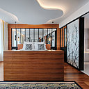 Aux pieds du lit, le coffre en bois cache un écran de télé rétractable.