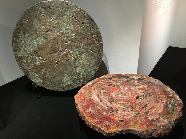 Présentées lors de l’exposition bruxelloise à Bozar, organisée du 18 août au 24 septembre 2017, table avec plateau en bois pétrifié d’Arizona, âgés de 225 ans, création en 1975. A la verticale, table « A ciel ouvert » avec plateau en fonte de bronze, création Chale Collection en 1972.