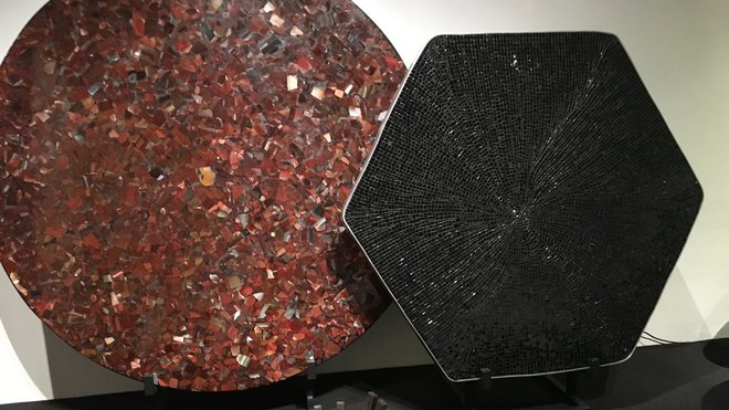 Présentées lors de l’exposition bruxelloise à Bozar, organisée du 18 août au 24 septembre 2017, table en agate cornaline rouge orangé, création Chale Collection en 1990 et modèle serti d’aluminium avec mosaïque en onyx noir, création Chale Collection en 1971. Au sol, coupe « Brasero » en fer forgé, création Chale collection en 1970.