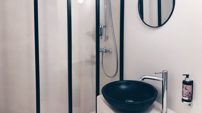 L’espace douche de la salle de bains est séparé du lavabo par une verrière qui permet de composer un lieu très lumineux.