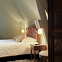 Sous les combles, il règne une atmosphère apaisante dans la chambre peinte en vert amande à l’éclairage doux.