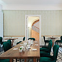 Dans la salle à manger, on prend son petit-déjeuner avec convivialité et gourmandise sur une grande table commune en bois brut. Murs tapissés de papier-peint, boiseries en sous bassement, chaises en velours.