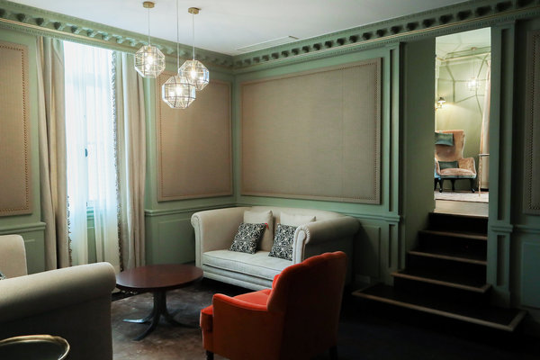 Un petit salon permet de se détendre dans l’intimité ; le vert doux, comme fil conducteur, les assises confortables, les panneaux façon tapissier, contribuent à rendre la pièce chaleureuse.