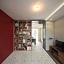 Le salon TV avec bibliothèque est personnalisé par un mur peint et des carreaux ciment au sol qui délimitent l’espace.