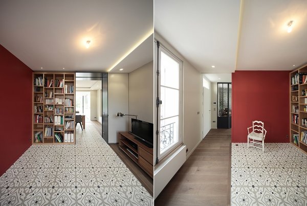 Le salon TV avec bibliothèque est personnalisé par un mur peint et des carreaux ciment au sol qui délimitent l’espace.