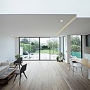 Le grand salon et double séjour s’ouvrent sur le jardin avec une terrasse en bois qui prolonge l’espace intérieur. Une verrière en toiture apporte un complément de lumière naturelle.