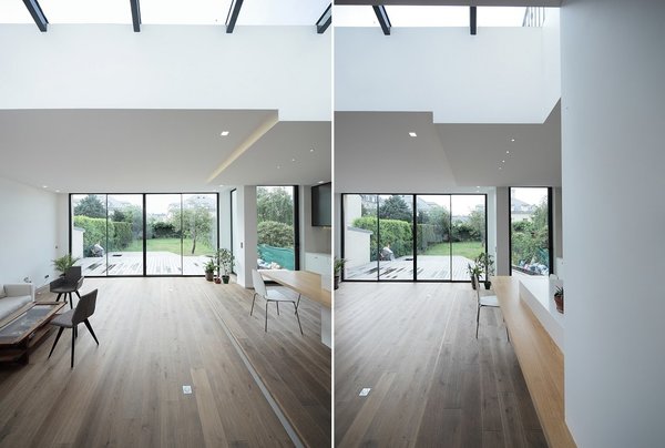 Le grand salon et double séjour s’ouvrent sur le jardin avec une terrasse en bois qui prolonge l’espace intérieur. Une verrière en toiture apporte un complément de lumière naturelle.