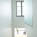 Dans la trémie de l’escalier, la boîte en verre sablé en porte-à-faux renferme la douche de la salle de bains de la suite parentale.