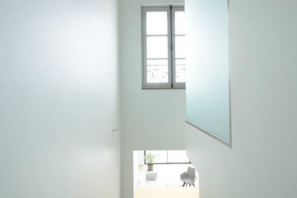 Dans la trémie de l’escalier, la boîte en verre sablé en porte-à-faux renferme la douche de la salle de bains de la suite parentale.