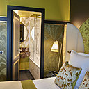 Les couleurs dorées de la chambre Jaune Opale s’associent avec une vasque de salle de bains en marbre brun Emperador.