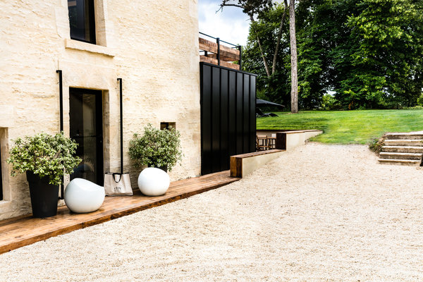 La maison est caractérisée par une extension en acier laqué noir qui s’ouvre sur une terrasse.