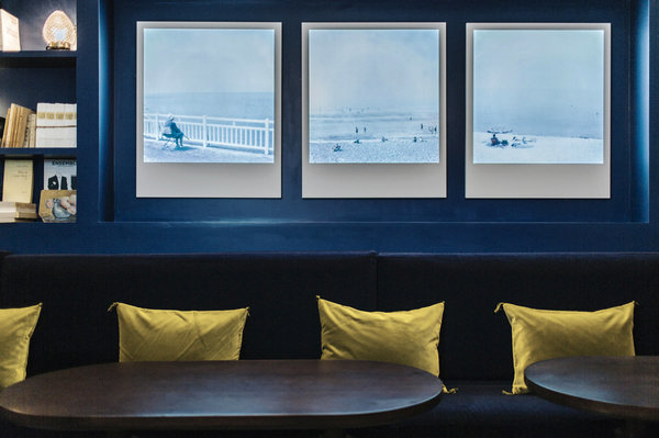 Dans la salle du petit déjeuner de l’Hôtel Handsome, une grande banquette et un triptyque de photos pour s’évader à la plage.