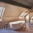 Une suite sous la pente du toit qui ressemblerait à une chambre installée dans l’ancien grenier d’une maison de campagne.