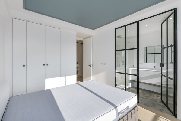 Le plafond de la chambre immaculée a été coloré en bleu pour offrir une certaine intimité à la pièce (coloris Stone Blue n° 86, chez Farrow and Ball).