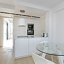 La cuisine (Ikea) offre de façades en laqué mat avec des poignées sur gorge très discrètes. Au sol, le carrelage s’immisce dans le parquet sans franche rupture, comme une fresque avec un effet de pas très délicat. Hotte abat-jour éclairante, modèle Juno chez Elica.