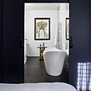 Dans la salle de bains, une baignoire en îlot en résine dont la forme rappelle le style Napoléon III. Sur le mur, un dessin de l’habit de lumière d’un torero réalisé par Christian Lacroix. Guéridon Napoléon III en papier mâché dans l’esprit des chinoiseries.