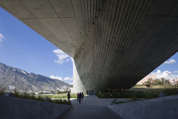 Centre Roberto Garza Sada Université de Monterrey (2012) situé dans le paysage montagneux du Nord-Est du Mexique. Cette structure monolithique et minimaliste de 6 étages sert de passerelle pour le campus et offre une vue imprenable sur la région.