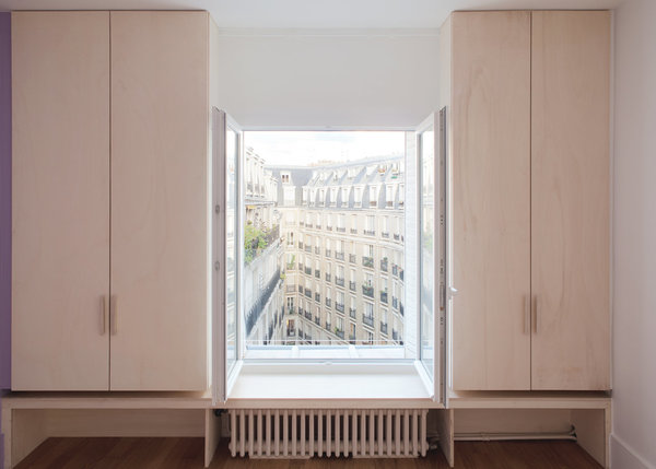 Du mobilier sur mesure a été intégré aux soupentes. Il rehausse ainsi fenêtres et balcons tout en laissant s’attarder le regard sur le paysage urbain. La fenêtre est ainsi encadrée de manière différenciée suivant l’usage de la pièce et de son orientation, côté rue ou cour.