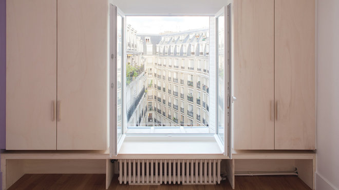 Du mobilier sur mesure a été intégré aux soupentes. Il rehausse ainsi fenêtres et balcons tout en laissant s’attarder le regard sur le paysage urbain. La fenêtre est ainsi encadrée de manière différenciée suivant l’usage de la pièce et de son orientation, côté rue ou cour.
