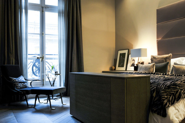 Dans la chambre des parents, tête de lit recouvert de satin (Dedar) et coffre qui cache un écran TV télescopique.