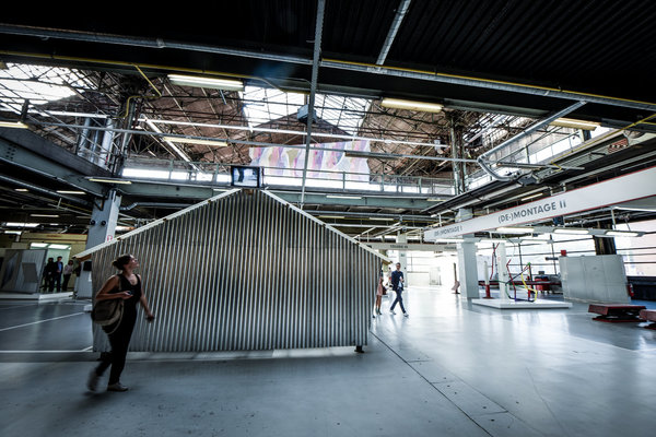 Dans l’ancien atelier de carrosserie, exposition « Tôles », avec l’œuvre Gladbeck, créée en 1985 par Reinhard Mucha. Elle se compose de deux abris de jardin en tôle ondulée, utilisés également sur les chantiers. Kanal/Centre Georges Pompidou.