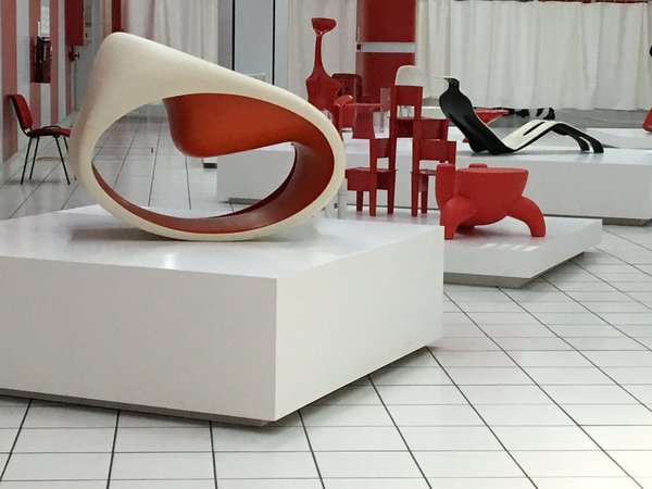Exposition « En rouge et blanc » avec, au premier plan, le siège MT 3 (à prononcer Empty) de Ron Arad, création 2005 : il s’agit d’un rocking-chair en monobloc de polyéthylène (plastique polymère bicolore) moulé par rotation avec formes creuses évidées.