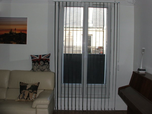 Après la pose du store vertical à bandes verticales avec les lames : perpendiculaires, les bandes verticales laissent passer la lumière.