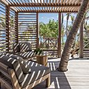 A gauche, les terrasses font parties des cottages, conçus comme des cabanes, dont elles sont le prolongement. A droite, sobre et élégante, la salle de bains est réalisée en bois local et apporte tout le confort d’un hôtel de luxe.