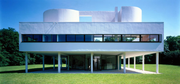 Le bâtiment extérieur de la villa Savoye forme un volume symétrique et lisse sur pilotis. La porte d’entrée se trouve sur la façade opposée.